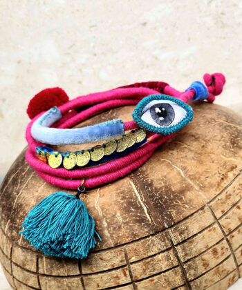 Βραχιόλι ροζ σκούρο πλεχτό τυλιχτό στο χέρι με κεντητό μάτι, κόκκινη και γαλάζια φούντα και βελούδινες κόκκινες, γαλάζιες και μπλε λεπτομέρειες