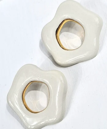 Χειροποίητα κεραμικά σκουλαρίκια σε σχήμα ασύμμετρο κύκλο με λευκό χρώμα και χρυσό σμάλτο. Κούμπωμα από επιχρυσωμένο ασήμι 925.