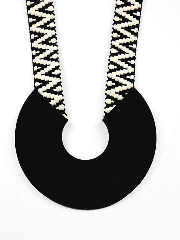 Χειροποίητο κολιέ πέταλο σε μαύρο χρώμα από plexi glass με υφαντό ασπρόμαυρο ιμάντα. Μήκος 48εκ.