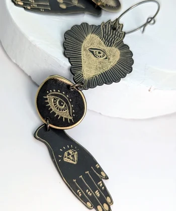 Χειροποίητα μακριά σκουλαρίκια από ορείχαλκο με επίχρυση χάραξη και χαραγμένα σύμβολα καρδιά-μάτι-χέρι.